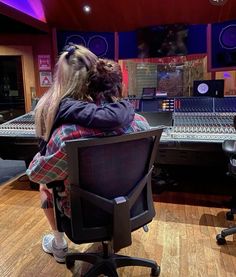 two people sitting in front of a mixing desk