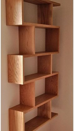 a wooden shelf sitting on top of a wall next to a white wall in a room