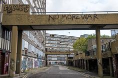 an abandoned city street with graffiti on the walls and overpasss that lead to buildings