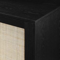 a black and white cabinet with woven panels