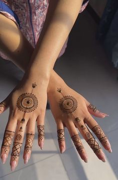 two hands with hendi designs on them