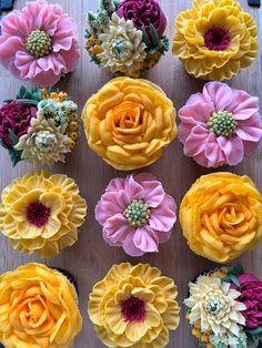 cupcakes decorated with yellow and pink flowers on top of a wooden table next to each other