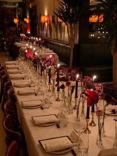 a long table is set with place settings and candles