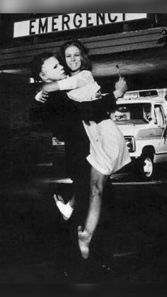 an old black and white photo of two people hugging