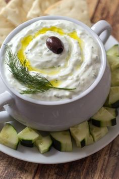 a white plate topped with cucumber and hummus