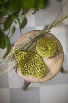 a yellow knitted hat sitting on top of a table next to a ball of yarn