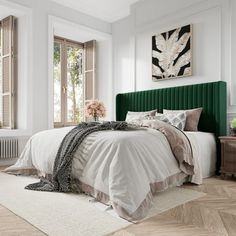 a green headboard on a bed in a white room with wooden floors and windows