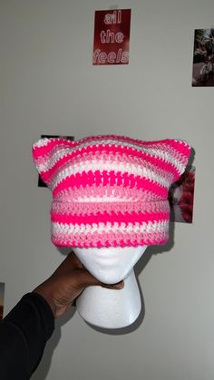 a pink and white crocheted hat on a mannequin's head