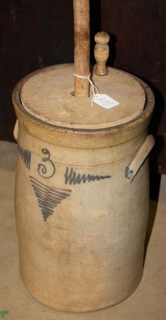 an old stone pot with a wooden stick sticking out of it's top and writing on the side