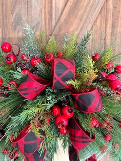 a christmas wreath with red berries and greenery