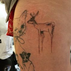 a person with a tattoo on their leg that has deer and dog pictures on it