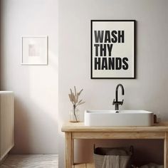 a bathroom sink sitting under a poster on the wall next to a radiator