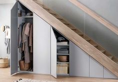 an open closet under the stairs in a house