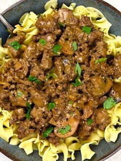 a bowl filled with pasta and meat covered in sauce