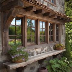 a stone house with windows and plants in the window sill