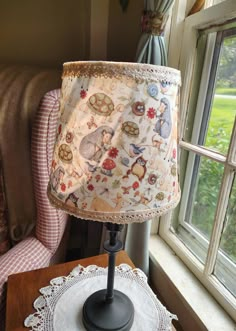 a lamp sitting on top of a table next to a window