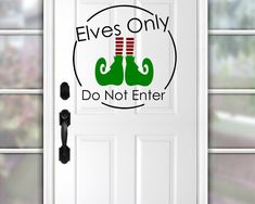 a white door with the words elves only do not enter and two green boxing gloves on it