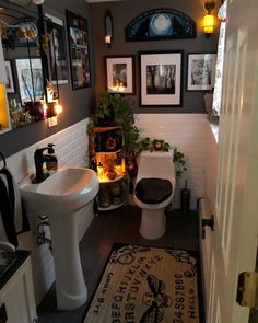 a bathroom with pictures on the wall and a rug in front of the sink area