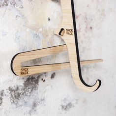 two wooden hooks hang from the side of a wall with stick track written on them