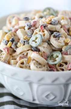 a white bowl filled with pasta salad on top of a table