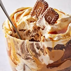 an ice cream sundae is topped with whipped cream, chocolate and cookie pieces in a glass bowl