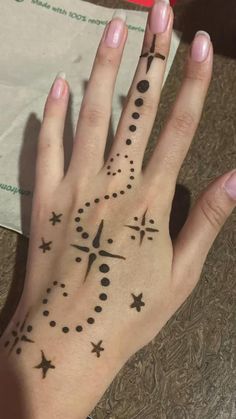 a woman's hand with a clock and stars tattoo on her left palm, next to a piece of paper