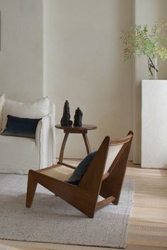 a living room filled with furniture and a wooden table on top of a hard wood floor