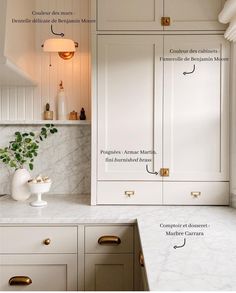 a kitchen with white cabinets and gold pulls on the doors, labeled in french words