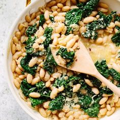 a white bowl filled with beans and spinach