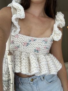 a close up of a person wearing a top with ruffles on the shoulders