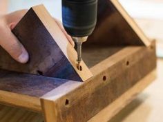 a person using a drill to cut wood with a small piece of wood in the middle