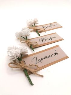 three tags with flowers tied to each other