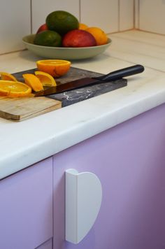 oranges and limes are sitting on the counter top next to a cutting board