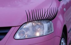 the front end of a pink car with eyelashes on it