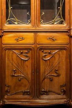 an antique wooden china cabinet with glass doors