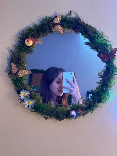 a woman taking a selfie in front of a mirror with flowers and butterflies on it