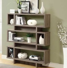 a bookshelf with several shelves and vases on top of it in a living room