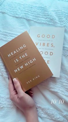 two books are laying next to each other on a white bed sheet with the words, good vibes, is the new high