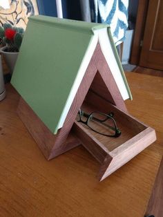 a pair of glasses sitting in a wooden box on a table next to a potted plant