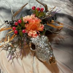 an animal's skull decorated with flowers and foliage