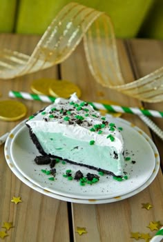 a piece of cake sitting on top of a white plate next to green and gold streamers