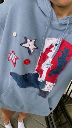 a person wearing a blue hoodie with red, white and blue stars on it