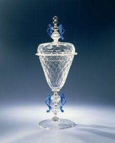 a clear glass vase with a blue handle