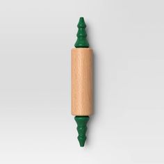 a green and wooden toothbrush holder on a white wall