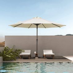 two lounge chairs under an umbrella next to a swimming pool