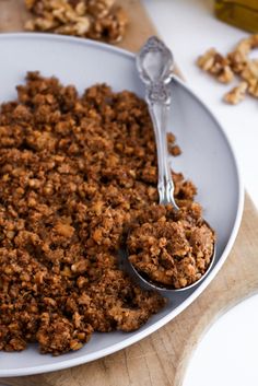 a white bowl filled with granola on top of a wooden cutting board