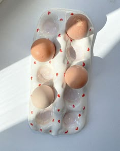 an egg carton with six eggs in it on a white surface, top view