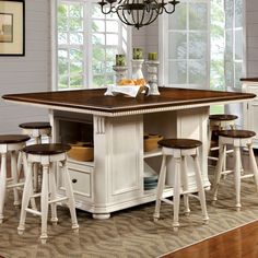 a kitchen island with stools and a chandelier