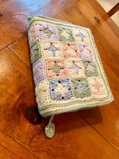 a crocheted blanket sitting on top of a wooden table