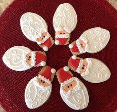 six decorated christmas cookies sitting on top of a red plate